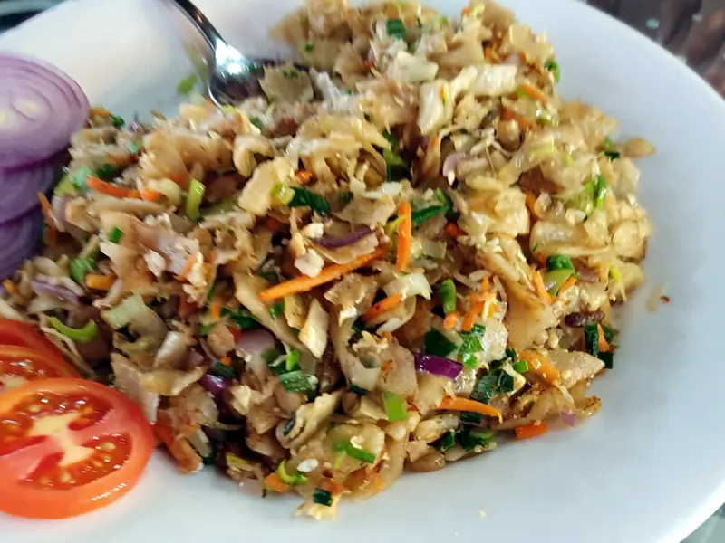 A plate of kottu with sliced red onion and tomato at Restaurant Two