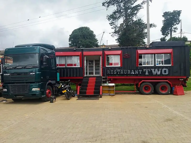 The Restaurant Two container dining car with its red steps, parked on the paved yard